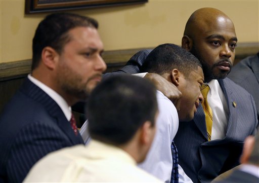 Defense attorney Walter Madison, right, holds his client, 16-year-old Ma'Lik Richmond, second from right, while defense attorney Adam Nemann, left, sits with his client Trent Mays, foreground, 17, in Steubenville, Ohio, on Sunday, as Juvenile Court Judge Thomas Lipps pronounces them both guilty of raping a drunken classmate.