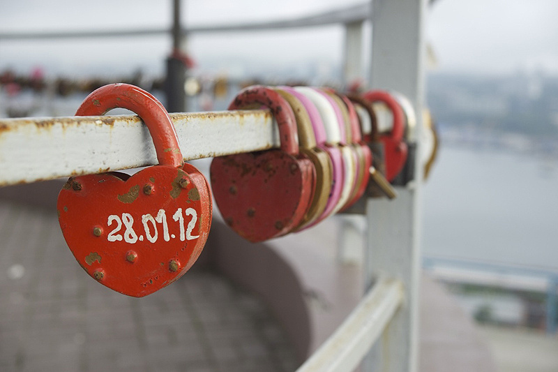 Newlyweds in Vladivostok, Russia, place heart-shaped locks, with the date of their wedding, on a railing on a hillside overlooking the city’s harbor.