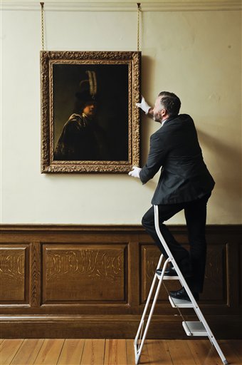 David Taylor, curator of pictures and sculpture at Buckland Abbey, adjusts the newly confirmed self-portrait by Rembrandt discovered at Devonshire Abbey, in Skipton, England. The masterpiece was gifted in 2010 to Britain's National Trust by the family estate of a wealthy property developer, and has now undergone detailed investigations led by the world's leading Rembrandt expert, Ernst van de Wetering, to determine its provenance before declaring it an original painting by the Dutch master.