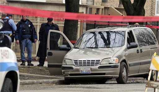 Chicago police investigate at the scene of a shooting where 6-month-old Jonylah Watkins was shot five times while her father was changing her diaper in a parked minivan in Chicago's Woodlawn neighborhood. The van can be seen with the window shattered from the shooting.