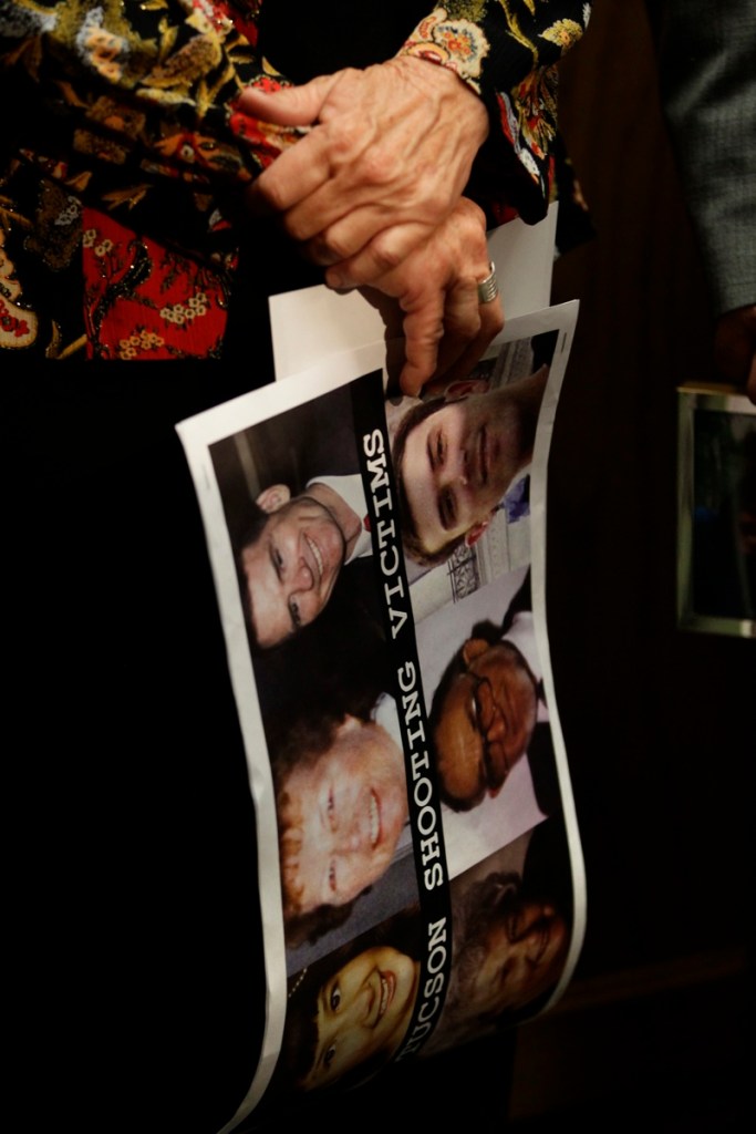 A participant in a news conference in favor of proposed gun control legislation holds a poster picturing victims from the Tucson shooting, inside the Colorado State Capitol, in Denver this month.