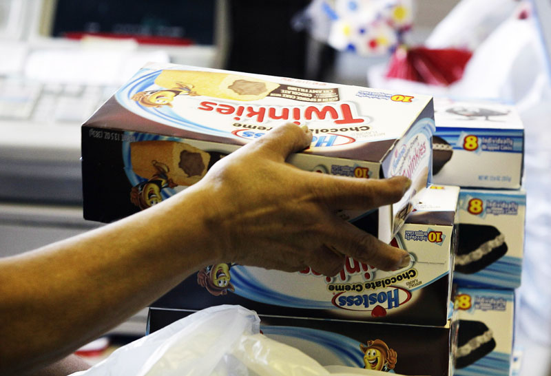 In this Nov. 16, 2012 file photo, a cashier rings up boxes of Hostess Twinkies and Cup Cakes at the Hostess Brands' bakery in Denver.