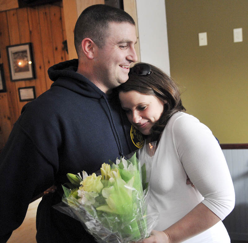 Megan McGuire hugs her husband, Travis, Wednesday March 20, 2013 moments after he surprised her by returning early from an Army deployment in Afghanistan to be present for the birth of their first child. Travis McGuire walked into the Depot in Gardiner and gave his wife a bouquet of flowers as she dined with family and friends.