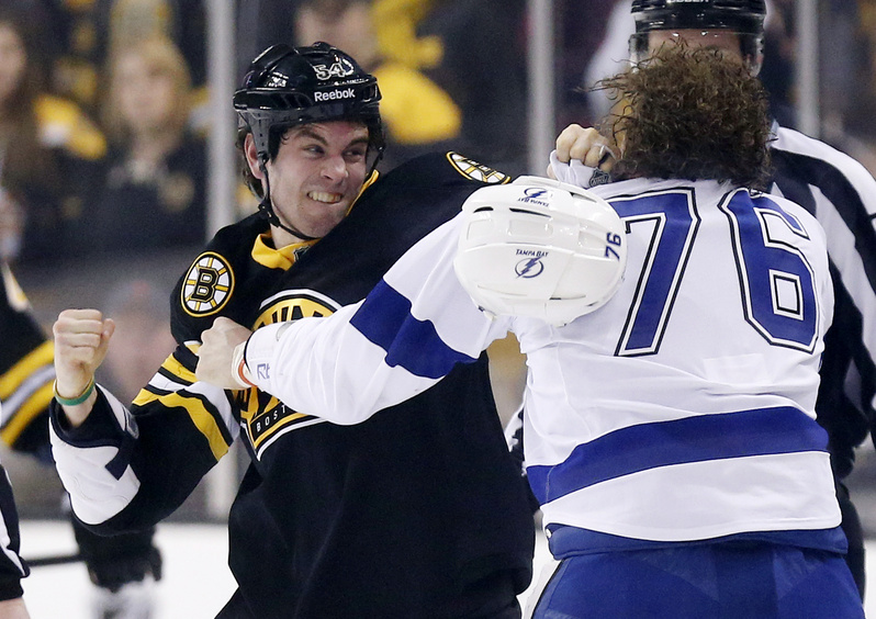 Adam McQuaid, left, of the Bruins and Tampa Bay's Pierre-Cedric Labrie fight during the first period Saturday in Boston.