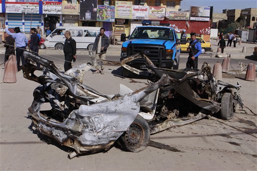 Iraqi security forces inspect the scene of a car bomb attack in the Shiite stronghold of Sadr City, Baghdad on Tuesday. Insurgents unleashed deadly attacks against Shiite areas of Baghdad, killing and wounding scores of people.
