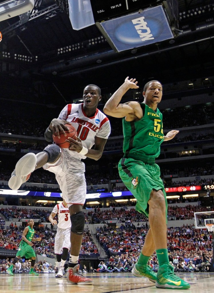 Louisville center Gorgui Dieng (10) grabs a rebound against Oregon center Tony Woods (55) during the second half of a regional semifinal in the NCAA college basketball tournament, Friday, March 29, 2013, in Indianapolis. (AP Photo/Michael Conroy)