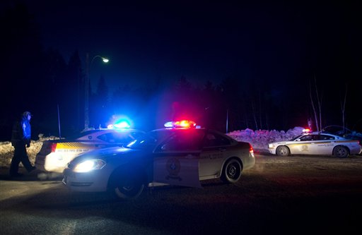 Police vehicles block a road just outside the town of Chertsey, Quebec on Sunday night, during a search for escaped prisoners. At least one escapee was tracked down hours after he fled.