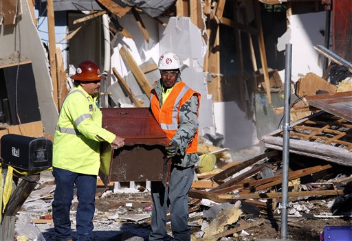 Demolition experts remove a piece of furniture from the home of Jeff Bush, 37, on Monday in Seffner, Fla.