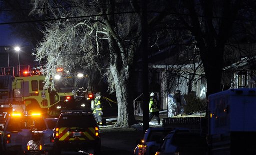 South Bend police and fire officials examine a home where a plane crashed near the South Bend Regional Airport on Sunday. The private jet struck three homes, authorities and witnesses said.
