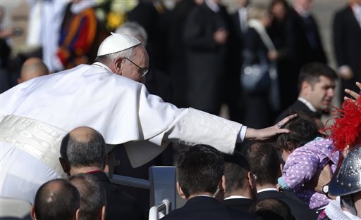 Pope Francis reaches out to touch a child as he arrives to his inauguration Mass in St. Peter's Square at the Vatican on Tuesday.