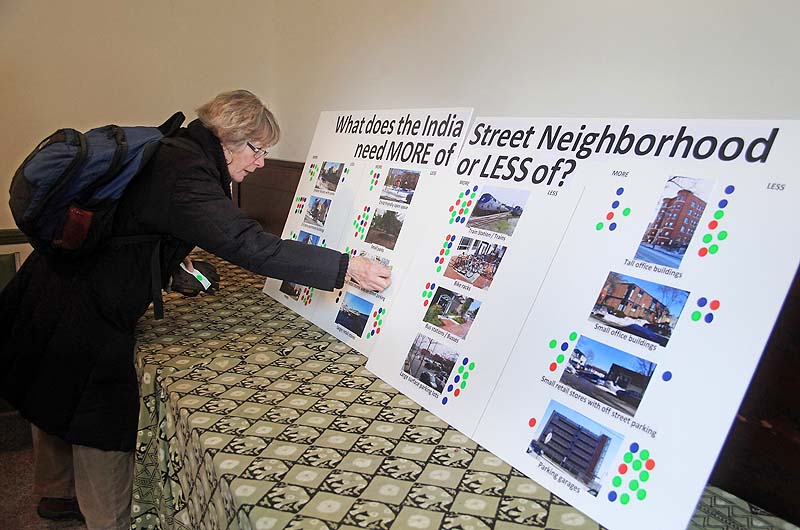 Elizabeth Streeter, a resident of Munjoy Hill in Portland, puts her opinion on a questionnaire board during an informal open house to consider the future of the India Street neighborhood, held at the Maine Jewish Museum on Saturday.