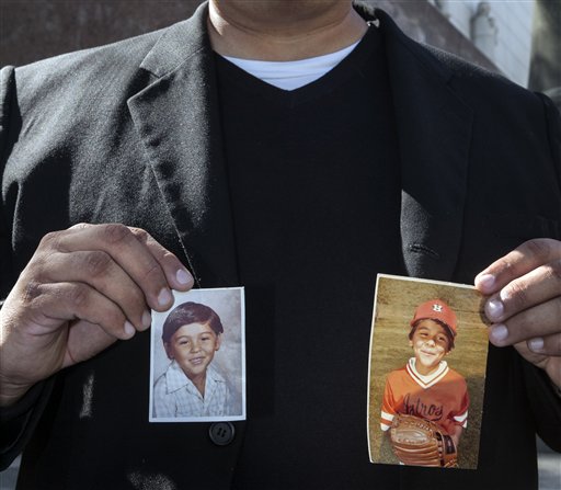 Michael Duran, a plaintiff in a sex abuse settlement with the Roman Catholic Archdiocese of Los Angeles, holds up pictures of himself when he was a child during a news conference to announce details of a nearly $10 million settlement of their lawsuits against the Archdiocese of Los Angeles Thursday, March 14, 2013. Duran was molested by ex-priest Michael Baker, who is now in jail after pleading guilty pleaded to a dozen sex charges. The U.S. church's challenges include recovering from the clergy sexual abuse scandal, which has resulted in the bankruptcies of prominent archdioceses and cost the Church in America an estimated $3 billion in legal settlements. (AP Photo/Damian Dovarganes)