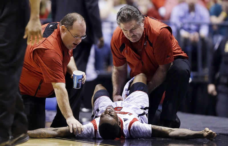 Medical personnel attend to Kevin Ware after the Louisville guard suffered an apparent broken leg during the NCAA Midwest Regional final Sunday against Duke.