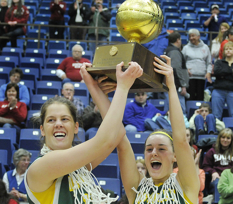 McAuley team captains Molly Mack and Allie Clement, right, hold up the state championship trophy after defeating Bangor 60-45 earlier this month.