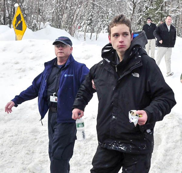 Staff photo by David Leaming Missing skier Nicholas Joy, 17, of Medford, Mass., is led to an ambulance Tuesday morning after spending two nights lost near Sugaloaf ski area.