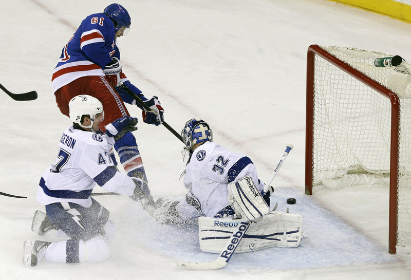 New York’s Rick Nash slips the puck behind Tampa Bay goaltender Mathieu Garon during third-period action of Thursday’s game, won by the Rangers.