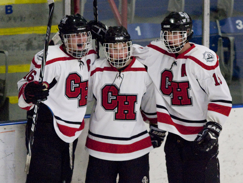 Camden Hills captain Jack Orne, left, celebrates with teammates after scoring his fourth goal in the Western Class B boys’ hockey semifinals Friday at the Colisee in Lewiston, sending the Windjammers to the regional final for the first time in their seven-year varsity hockey program.