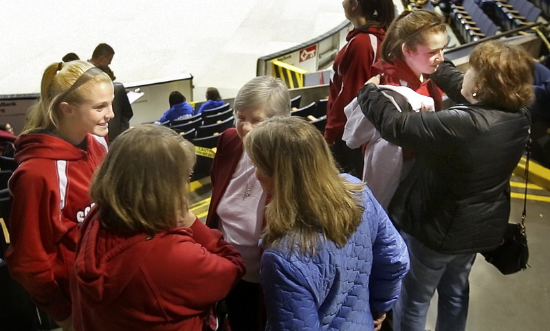 Senior Courtney Alofs is comforted by her mother, Carlene, far right, after the Scarborough High School girls basketball team played its final game Feb. 22. At left, senior Maria Philbrick talks with her family members.