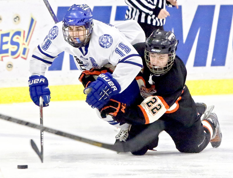 Kyle Lemelin, left, of Lewiston is brought down by Ryan Maciejewski of Brunswick as they chase the puck Saturday during Lewiston’s 10-0 victory in an Eastern Class A semifinal.