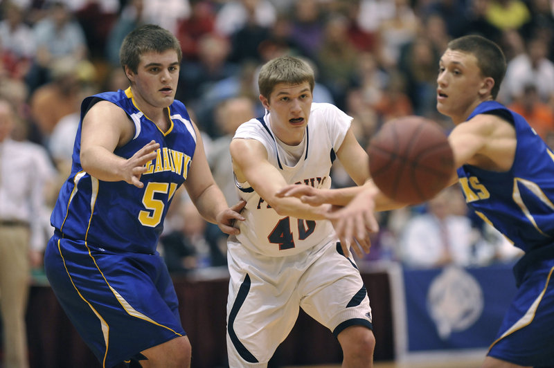 Cody Herbest, center, of Penquis Valley finds room to pass Saturday night between Linc Simmons, left, and Anthony DiMauro of Boothbay during Penquis’ 61-54 victory in the Class C state final at the Bangor Auditorium.