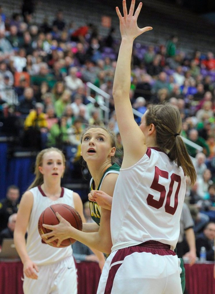 Olivia Smith looks for an opening against Bangor’s Cordelia Stewart in the Class A state championship game Saturday. Smith scored 20 points in McAuley’s 60-45 victory.