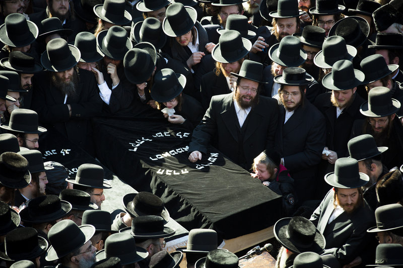 Members of an ultra-orthodox Jewish community gather Sunday for the funeral of two expectant parents who were killed in a car accident that morning in Brooklyn, N.Y.