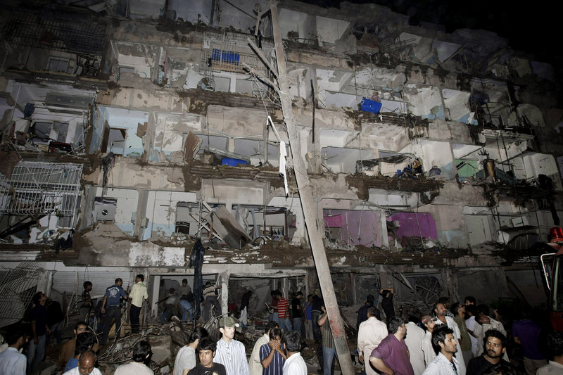 Pakistanis gather at the site of a bombing Sunday in a neighborhood of Karachi dominated by Shiite Muslims.
