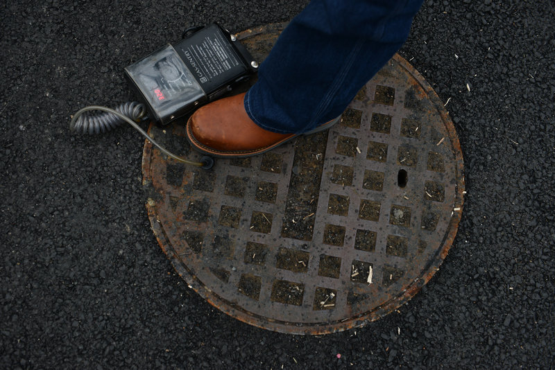 Bob Ackley, a gas leakage specialist, uses a combustible gas indicator to test the outpouring of methane gas from a manhole in the affluent Spring Valley neighborhood of Washington, D.C.