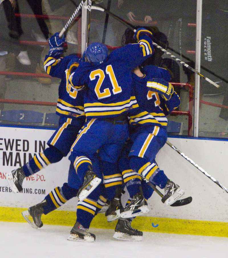 Isac Nordstrom of Falmouth is mobbed by teammates Tuesday night after scoring the tying goal with 3:26 remaining. The Yachtsmen added a goal moments later to beat Scarborough and win Western Class A.
