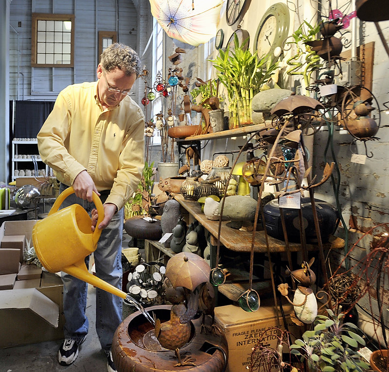 Dan Kennedy, owner of Sawyer Company, fills one of his many whimsical metal sculptured water fountains that move to the flow of the water in his vendor display at the Portland Flower Show on Wednesday, March 06, 2013. He used "a little of everything" from his three stores, Sawyer & Company, Harmon's & Barton's and Minott's Flower shops in Portland to offer "everything for the garden and more."