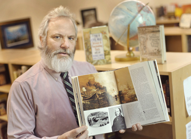 Andrew Bryan of Holden holds a National Geographic book that has a depiction of the famous naval battle at Hampton Roads, Va., between the Merrimack and the Monitor in 1862 during the Civil War. His great-great-great-uncle served aboard the USS Monitor.