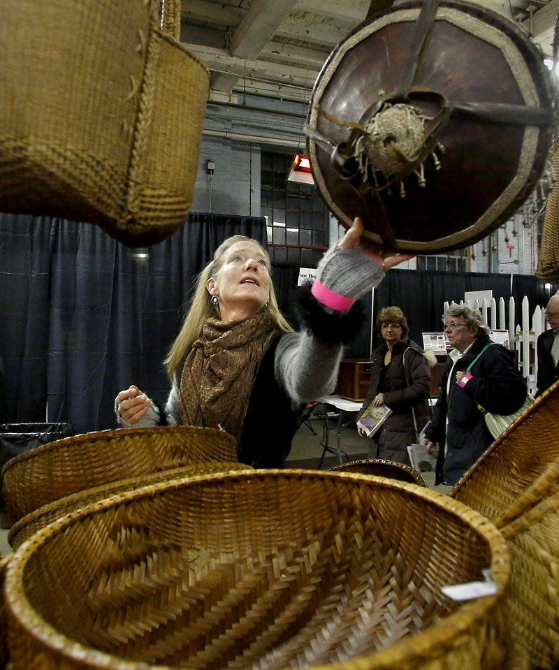 Carmen Serier of Bowdoinham looks at hand-made baskets at the The Children's Initiative booth during the opening night of the Portland Flower Show at the Portland Company Complex in Portland on March 6, 2013. The baskets are made in a village in Vietnam with the proceeds used to build schools.