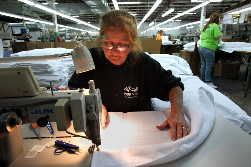 Karen Pias sews the finishing edge on a towel at 1888 Mills in Griffin, Ga. Walmart will sell 1888’s Made Here towels, as part of the onshoring trend moving some manufacturing back to the U.S., but technology advancements mean fewer workers are needed for production.