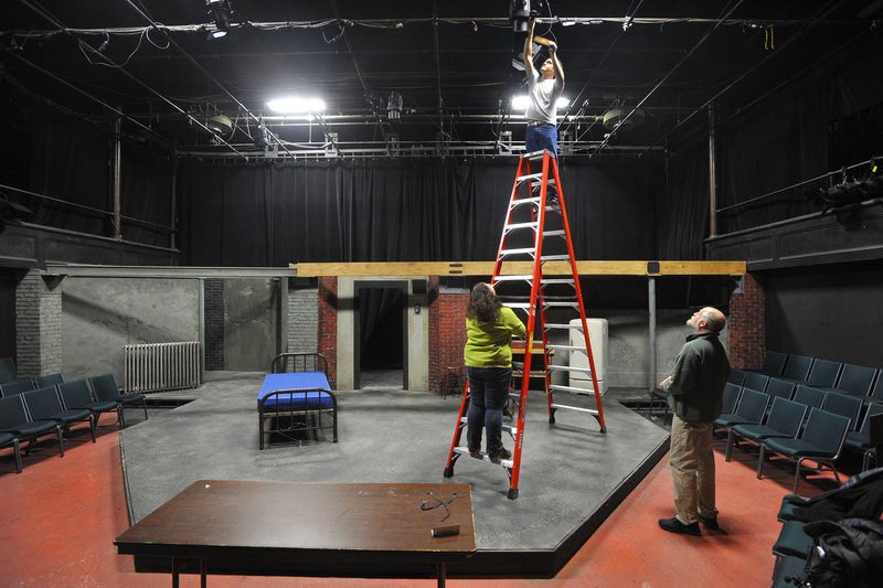 UMF student Richard Russell, an actor in an upcoming play, attaches colored gels to stage lights with assistance from stage crew member Leigh Welch (on ladder) and theater designer Dan Spilecki.