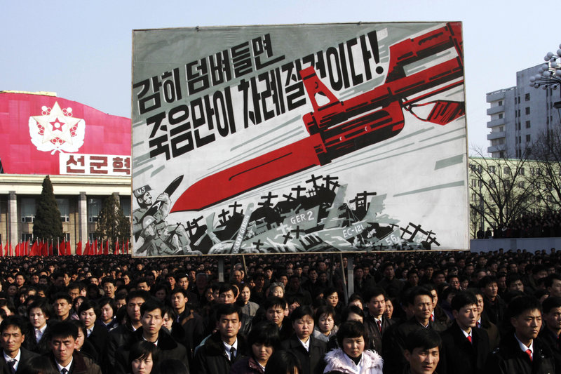 North Koreans attend a rally this week in Pyongyang to support a Supreme Command statement that vows to cancel the 1953 cease-fire ending the Korean War. A billboard in the background depicts a bayonet pointed at U.S. soldiers that reads: “If you dare invade, only death will be waiting for you!”
