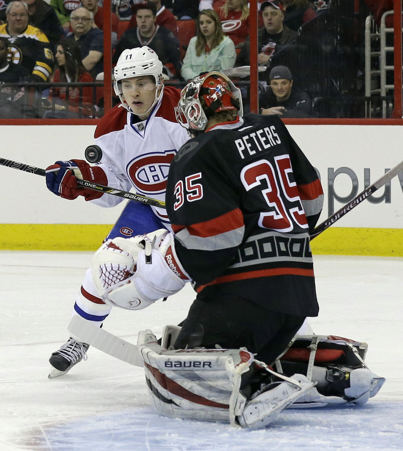 Montreal’s Brendan Gallagher tries to bunt the puck past Carolina goaltender Justin Peters during Thursday’s game in Raleigh, N.C., won by the Canadiens.