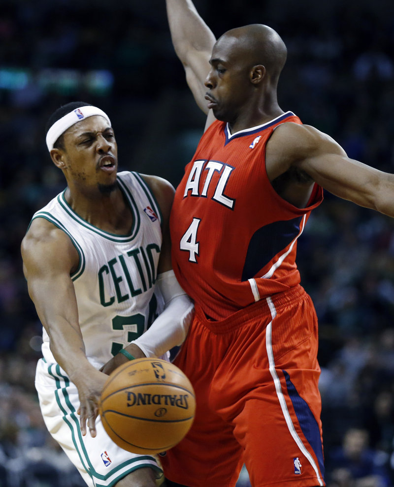 Boston’s Paul Pierce slips a pass past Atlanta’s Anthony Tolliver during first-quarter action of Friday’s game in Boston, won by the Celtics.