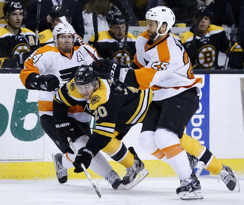 Boston forward Daniel Paille avoids being sandwiched by Philadelphia’s Kimmo Timonen, left, and Maxime Talbot during Saturday’s game in Boston, won by the Bruins, 3-0.