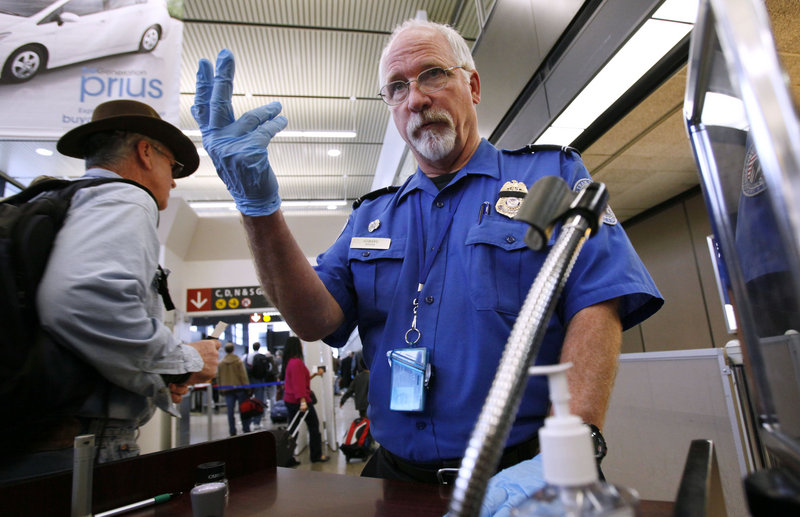 Transportation Security Administration officer Robert Howard signals a traveler forward at a Seattle-Tacoma International Airport security checkpoint in 2010. Airline workers are urging the TSA to rethink a move to allow knives on board airplanes.