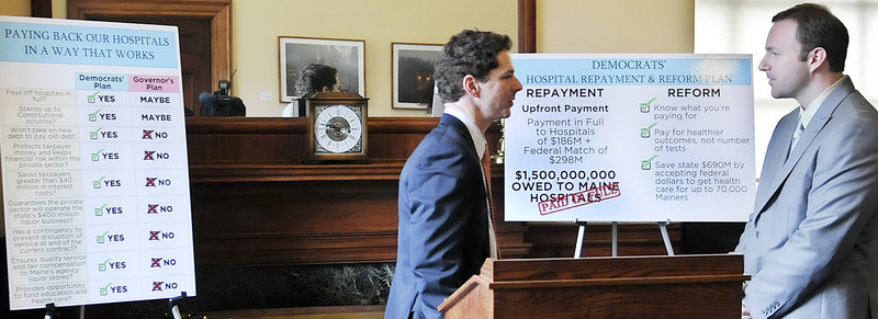 Senate President Justin Alfond, D-Portland, left, confers with Speaker of the House Mark Eves, D-North Berwick, after they unveiled a plan to repay state debt to hospitals by expanding the Medicaid program and receiving an upfront payment from the winning bidder of the state liquor contract.