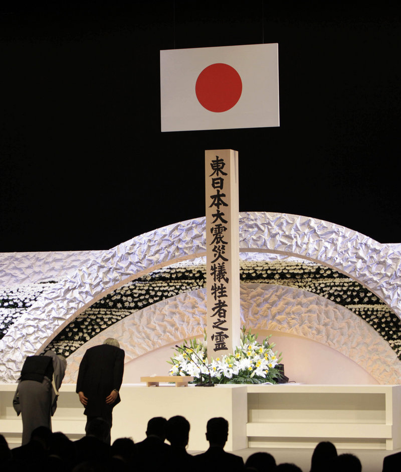 Japanese Emperor Akihito, right, and Empress Michiko bow Monday to pay tribute to the victims of the 2011 earthquake and tsunami at the national memorial service in Tokyo.