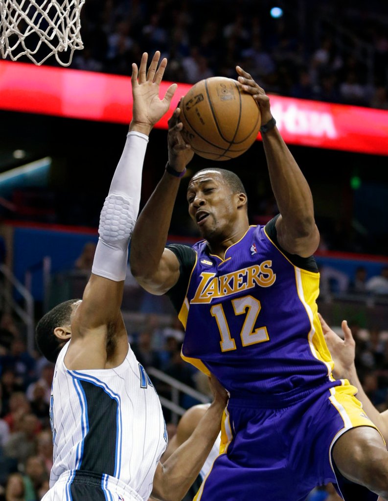 Dwight Howard of the Lakers goes up against Orlando’s Tobias Harris in Tuesday’s 98-81 win at Orlando, Fla. Howard tied his NBA record of 39 free-throw attempts.