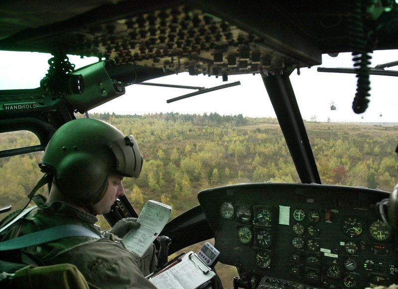 In this October 2001 file photo, Dean Dumond, a helicopter pilot with the 1st of the 137th Aviation Battalion of the Maine Army National Guard, checks flight notes while flying over Canadian Forces Base Gagetown in New Brunswick, Canada.