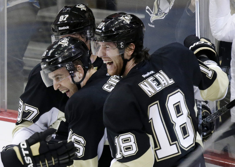Brandon Sutter, middle, is all smiles with Sidney Crosby, left, and James Neal after scoring the winning goal late in the third period against the Bruins Tuesday night in Pittsburgh. The Penguins wiped out a two-goal deficit late in the third period to win their sixth straight.