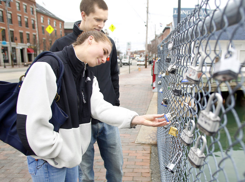 Sarah Rengold and her boyfriend Erik Born from Virginia read messages written on padlocks hung on a waterfront fence in Portland. Love locks also appear on bridges and fences in Paris, Moscow, New York City and elsewhere.