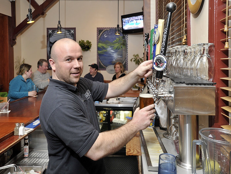 Bartender Chris Salamone pours a Frye’s Leap draft from one of the many Sebago Brewing taps at the popular spot in Gorham.