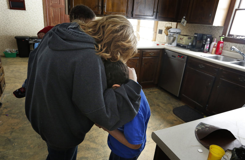 Marie Beaulieu comforts her son Shavar, 8, in their Jay home late last month, after he apologized for yelling at her. The Beaulieus adopted him after taking him in as a foster child.