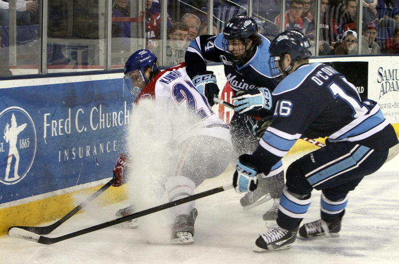 UMass-Lowell’s Zack Kamrass tries to avoid being sandwiched by Maine’s Brice O’Connor, 16, and Conor Riley, 44, during Thursday night’s Hockey East opener at the Tsongas Arena in Lowell, won by the River Hawks 4-3.