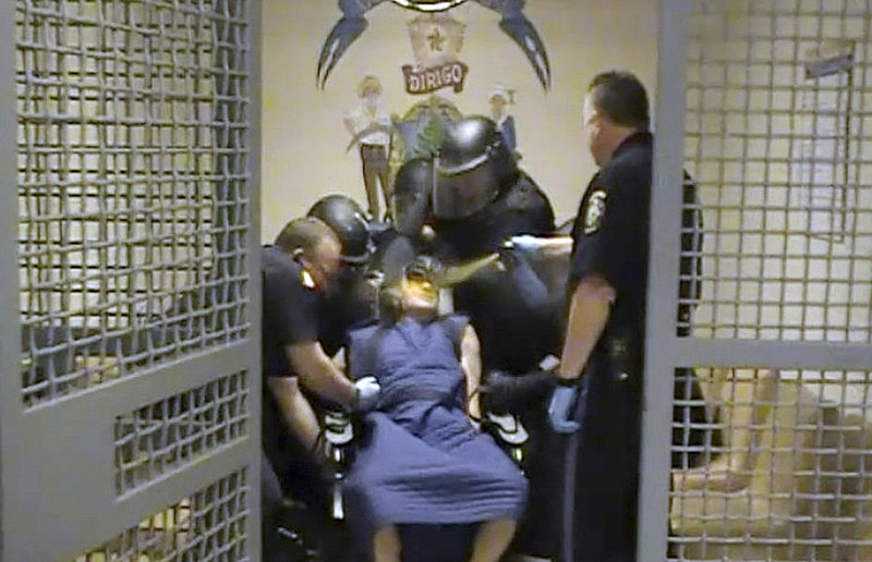 In this video image, Capt. Shawn Welch sprays OC spray into the face of Paul Schlosser who is bound in a restraint chair after the inmate spit at an officer on June 10, 2012.