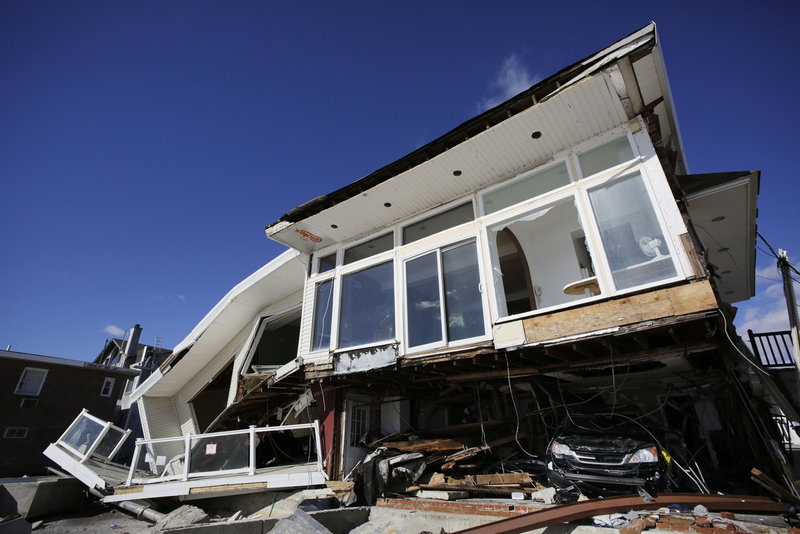 A car, lower right, is trapped in the wreckage of a beachfront house in the Far Rockaways in the Queens borough of New York in January, three months after Hurricane Sandy. States across the Northeast are creating plans to prepare for effects of climate change, but in Maine, Gov. Paul LePage’s administration halted creation of a climate adaptation strategy.